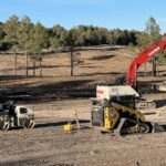 Red excavator and heavy equipment on dirt