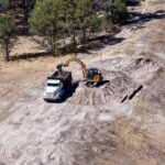 Excavator loading dump truck at construction site