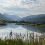 Mountain lake with dock and grassy foreground