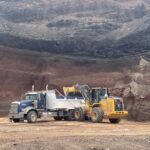 Wheel loader filling dump truck at quarry