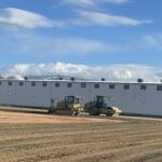 Two rollers beside white modular building
