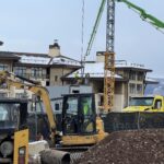 Excavator and crane at snowy construction site
