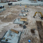 Aerial view of construction footings and excavator