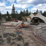 Construction site with excavators and workers near tents