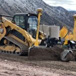 CAT compact track loader grading soil near mountains