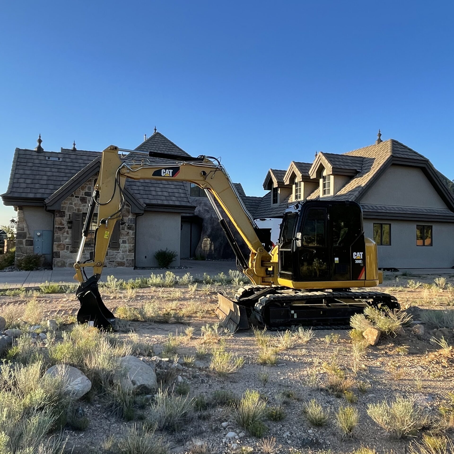 Yellow excavator parked in front of house